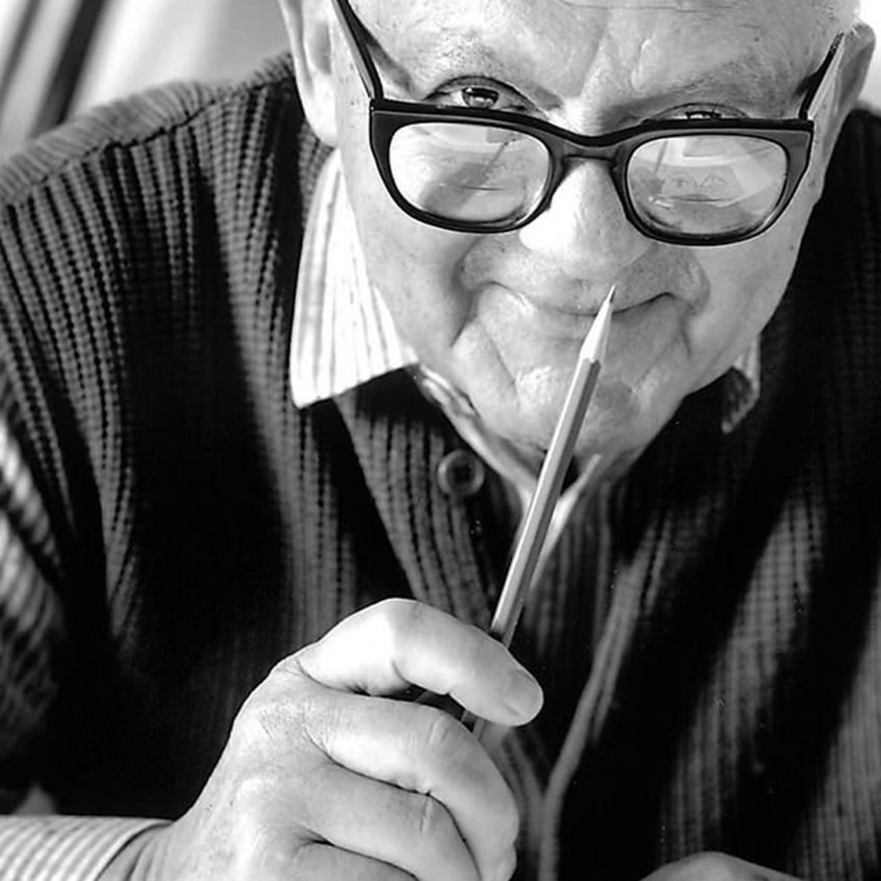 Paul Rand holding up a pencil.